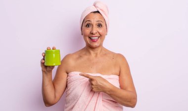 Oldukça orta yaşlı bir kadın heyecanlı ve şaşırmış görünüyor. duş ve saç ürünü konsepti