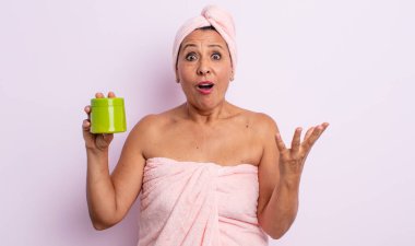 Oldukça orta yaşlı bir kadın son derece şaşırmış ve şok olmuş hissediyor. duş ve saç ürünü konsepti