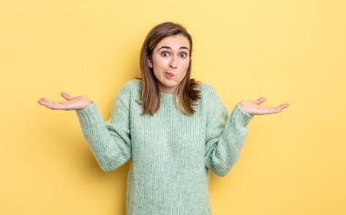 Genç güzel kız şaşkın ve kafası karışık, şüpheci, farklı seçenekleri tartıyor ya da komik bir ifadeyle seçiyor.