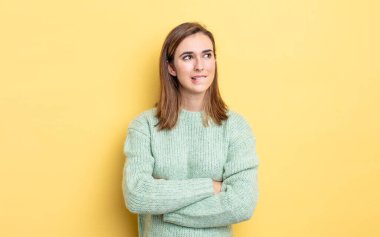 Genç, güzel bir kız şüphe ediyor ya da düşünüyor, dudağını ısırıyor ve kendini güvensiz ve gergin hissediyor, kenarda yer arıyor.