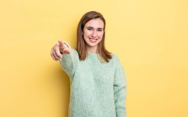 Genç ve güzel bir kız kameraya bakıyor. Tatmin olmuş, kendinden emin, dostane bir gülümsemeyle. Seni seçiyor.