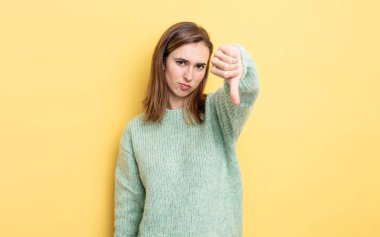 Genç ve güzel bir kız kızgın, sinirli, hayal kırıklığına uğramış ya da hoşnutsuz, ciddi bir bakışla başparmaklarını göstermiyor.