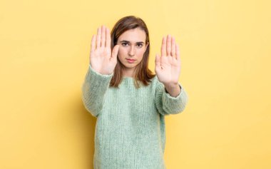 Genç ve güzel bir kız ciddi, mutsuz, kızgın ve hoşnutsuz görünüyor. Ya da her iki avucunun içinde de dur diyor.