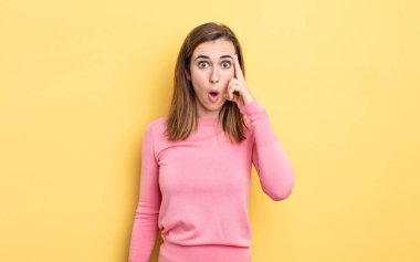 Genç güzel kız şaşırmış, ağzı açık, şok olmuş, yeni bir düşünce, fikir ya da konsept keşfediyor.