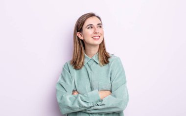 Genç, güzel bir kız mutlu, gururlu ve umutlu, merak ediyor ya da düşünüyor, çapraz kollarla fotokopi çekmeye çalışıyor.