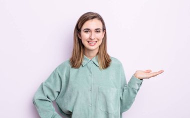 Genç, güzel bir kız gülümsüyor, kendinden emin, başarılı ve mutlu hissediyor, fotokopi alanında fikir veya konsept gösteriyor.