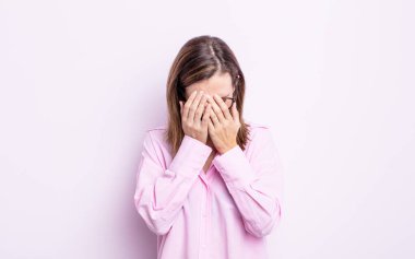 Genç, güzel bir kız üzgün, hayal kırıklığına uğramış, gergin ve depresif, iki eliyle yüzünü kaplayan, ağlayan