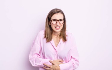 Genç, güzel bir kız endişeli, hasta, hasta ve mutsuz hissediyor. Ağrılı bir mide ağrısı ya da grip geçiriyor.