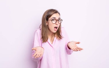 young pretty girl feeling clueless and confused, having no idea, absolutely puzzled with a dumb or foolish look