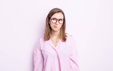 Genç ve güzel kız kafası karışmış görünüyor, merak ediyor veya bir sorunu çözmeye çalışıyor veya düşünüyor.