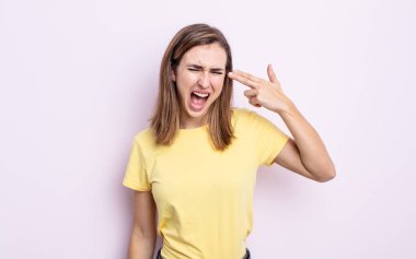 Genç ve güzel bir kız mutsuz ve stresli görünüyor, intihar jesti elle silah işareti yapıyor, kafasını işaret ediyor.