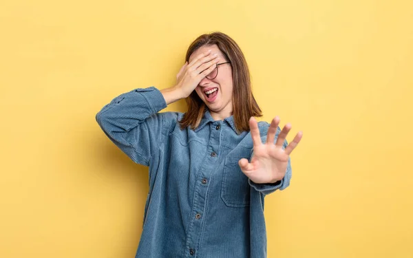 若い可愛い女の子が手で顔を覆いカメラを止めたり写真や写真を拒否したり — ストック写真