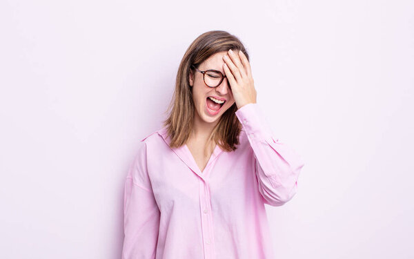 Молодая красивая девушка смеется и хлопает по лбу, как будто говорит да! Я забыл или это была глупая ошибка 