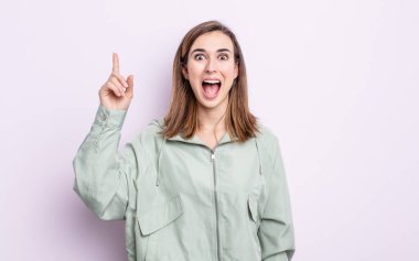 Genç ve güzel bir kız bir fikri fark ettikten sonra mutlu ve heyecanlı bir dahi gibi hissediyor, neşeli bir şekilde parmağını kaldırıyor, eureka!