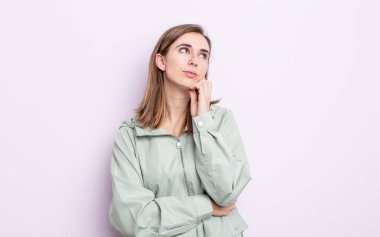 Genç güzel kız düşünceli, meraklı ya da hayal kuruyor, hayal kuruyor ve uzayı kopyalamak için yukarı bakıyor.