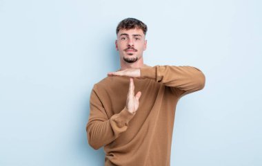 Genç yakışıklı adam ciddi, sert, kızgın ve canı sıkkın görünüyor.