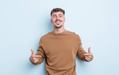 Genç yakışıklı adam gururlu, kibirli, mutlu, şaşırmış ve tatmin olmuş görünüyor, kendini gösteriyor, kazanan gibi hissediyor.