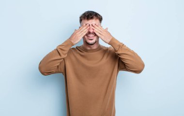 Genç yakışıklı adam gülümsüyor ve mutlu hissediyor, iki eliyle gözlerini kapatıyor ve inanılmaz bir sürpriz bekliyor.