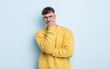 Genç yakışıklı adam ciddi görünüyor, kafası karışık, kararsız ve düşünceli, seçenekler ve seçimler arasında şüpheci.