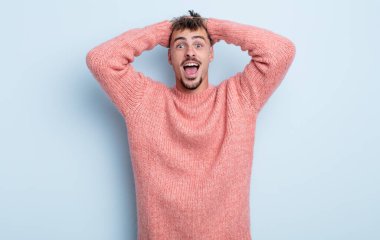 Genç yakışıklı adam el ele tutuşuyor, ağzı açık, son derece şanslı, şaşırmış, heyecanlı ve mutlu hissediyor.