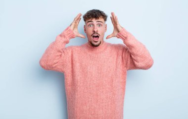 Genç yakışıklı adam elleri havada bağırıyor, öfkeli, sinirli, stresli ve üzgün hissediyor.