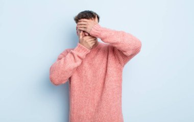 Genç yakışıklı adam kameraya hayır diyen iki eliyle yüzünü kapatıyor! Resimler reddediliyor ya da yasaklanıyor