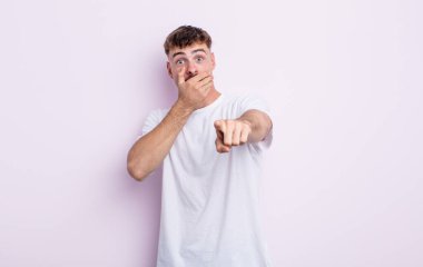 Genç yakışıklı adam sana gülüyor, kamerayı işaret ediyor ve seninle dalga geçiyor ya da alay ediyor.