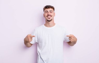 Genç yakışıklı adam gururlu, kibirli, mutlu, şaşırmış ve tatmin olmuş görünüyor, kendini gösteriyor, kazanan gibi hissediyor.