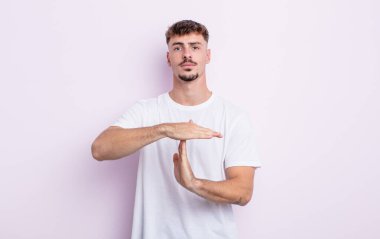 Genç yakışıklı adam ciddi, sert, kızgın ve canı sıkkın görünüyor.