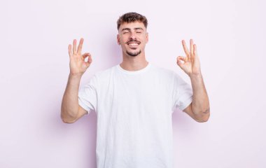 Genç yakışıklı adam konsantre olmuş ve meditasyon yapıyor, kendini tatmin olmuş ve rahatlamış hissediyor, düşünüyor ya da bir seçim yapıyor.