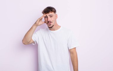 Genç yakışıklı adam mutlu, şaşkın ve şaşırmış görünüyor, gülümsüyor ve inanılmaz ve inanılmaz iyi haberleri fark ediyor.