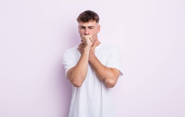 Gırtlağı ağrıyan, grip semptomları gösteren, ağzı kapalı öksüren genç yakışıklı bir adam.