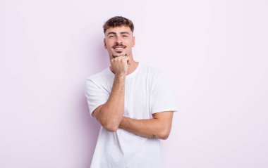 Genç yakışıklı adam gülümsüyor, hayattan zevk alıyor, mutlu, arkadaş canlısı, tatmin olmuş ve tasasız.