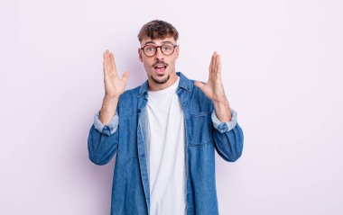 Genç yakışıklı adam şok olmuş ve şaşkın bakıyor, inanılmaz bir şey fark ettiğinde çenesi şaşkın şaşkın