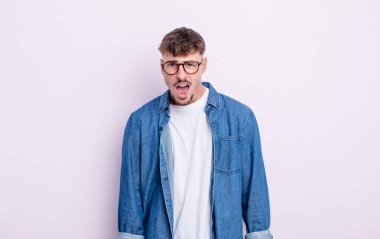 Şok olmuş, kızgın, sinirli ya da hayal kırıklığına uğramış, ağzı açık ve öfkeli genç bir adam.