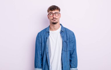 Genç ve yakışıklı adam kafası karışmış görünüyor, merak ediyor ya da bir sorunu çözmeye çalışıyor ya da düşünüyor.