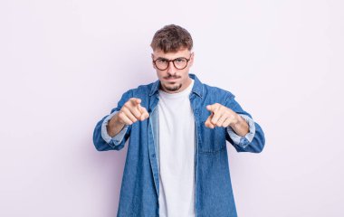 Genç ve yakışıklı bir adam kameraya hem parmaklarını hem de kızgın yüzünü göstererek sana görevini yapmanı söylüyor.