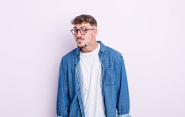 Aptal, çılgın, şaşkın bir ifadeyle genç yakışıklı adam, yanakları şişmiş, doldurulmuş, şişman ve yemekle dolu.