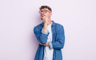 Genç yakışıklı adam düşünüyor, kuşkulu ve şaşkın hissediyor, farklı seçeneklerle, hangi kararı vereceğini merak ediyor.