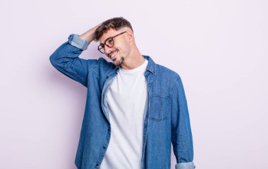 Genç yakışıklı adam neşeyle ve tesadüfen gülümsüyor, olumlu, mutlu ve kendinden emin bir bakışla göğüs göğüse.