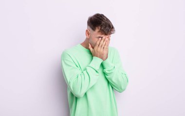 Genç yakışıklı adam üzgün, hayal kırıklığına uğramış bir bakışla gözlerini kapatıyor umutsuzluk, ağlama, yan bakış