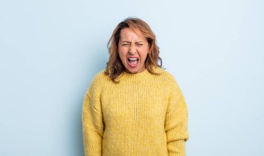 Orta yaşlı bir kadın agresif bir şekilde bağırıyor, sinirli, sinirli, öfkeli ya da sinirli görünüyor, hayır diye bağırıyor.