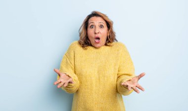 Orta yaşlı bir kadın inanılmaz bir sürprizle şaşkın ve şaşkın.
