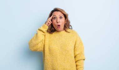 Orta yaşlı kadın şaşırmış, ağzı açık, şok olmuş, yeni bir düşünce, fikir ya da konsept keşfediyor.