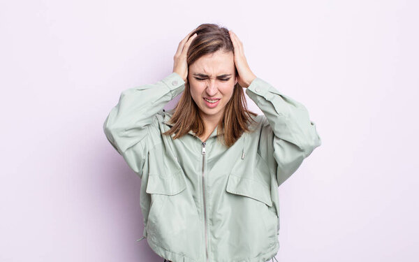 young pretty girl feeling stressed and frustrated, raising hands to head, feeling tired, unhappy and with migraine