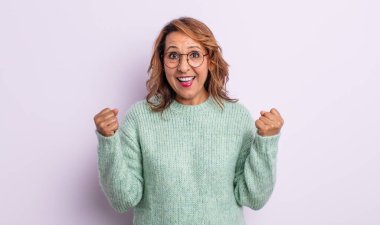 Orta yaşlı kadın şaşkın, heyecanlı ve mutlu hissediyor, gülüyor ve başarıyı kutluyor,!