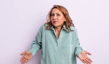 middle age woman feeling clueless and confused, having no idea, absolutely puzzled with a dumb or foolish look