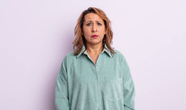 Orta yaşlı bir kadın üzgün ve mızmızlanıyor, mutsuz bir bakışla, negatif ve hayal kırıklığına uğramış bir tavırla ağlıyor.