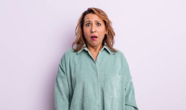 Orta yaşlı kadın korkmuş ve şok olmuş hissediyor, ağzı açık şaşkınlık içinde.