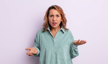 Orta yaşlı bir kadın bilgisiz ve kafası karışık, hangi seçeneği seçeceğinden emin değil, merak ediyor.